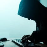 Hooded computer hacker hacking network