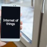 A person sees a white inscription on a black smartphone display that holds in his hand