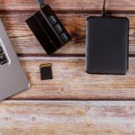 Photographers desktop workspace external backup disk hard drive connected to laptop computer