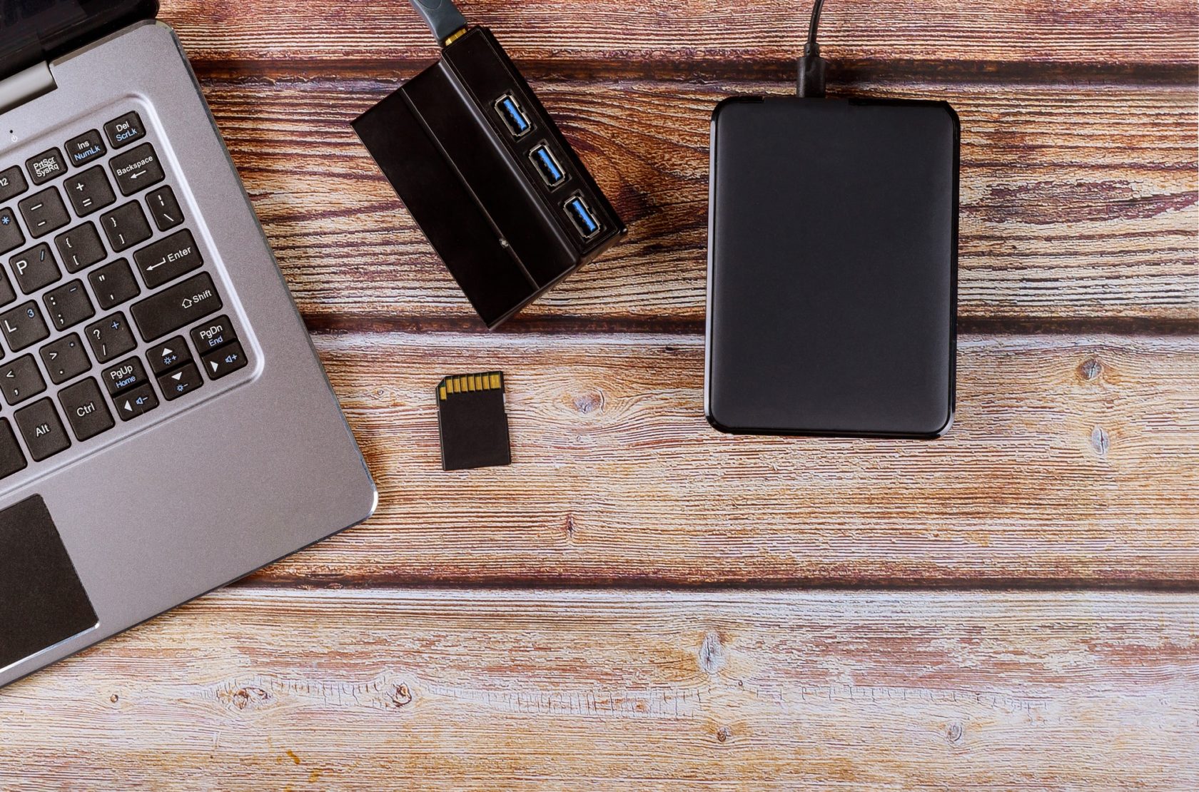 Photographers desktop workspace external backup disk hard drive connected to laptop computer