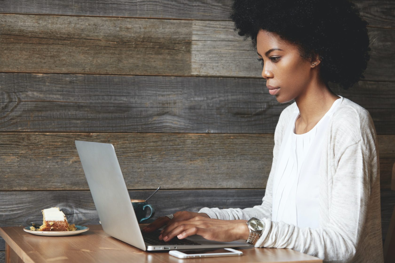Portrait of young attractive African female blogger, typing a new challenging post during lunchtime