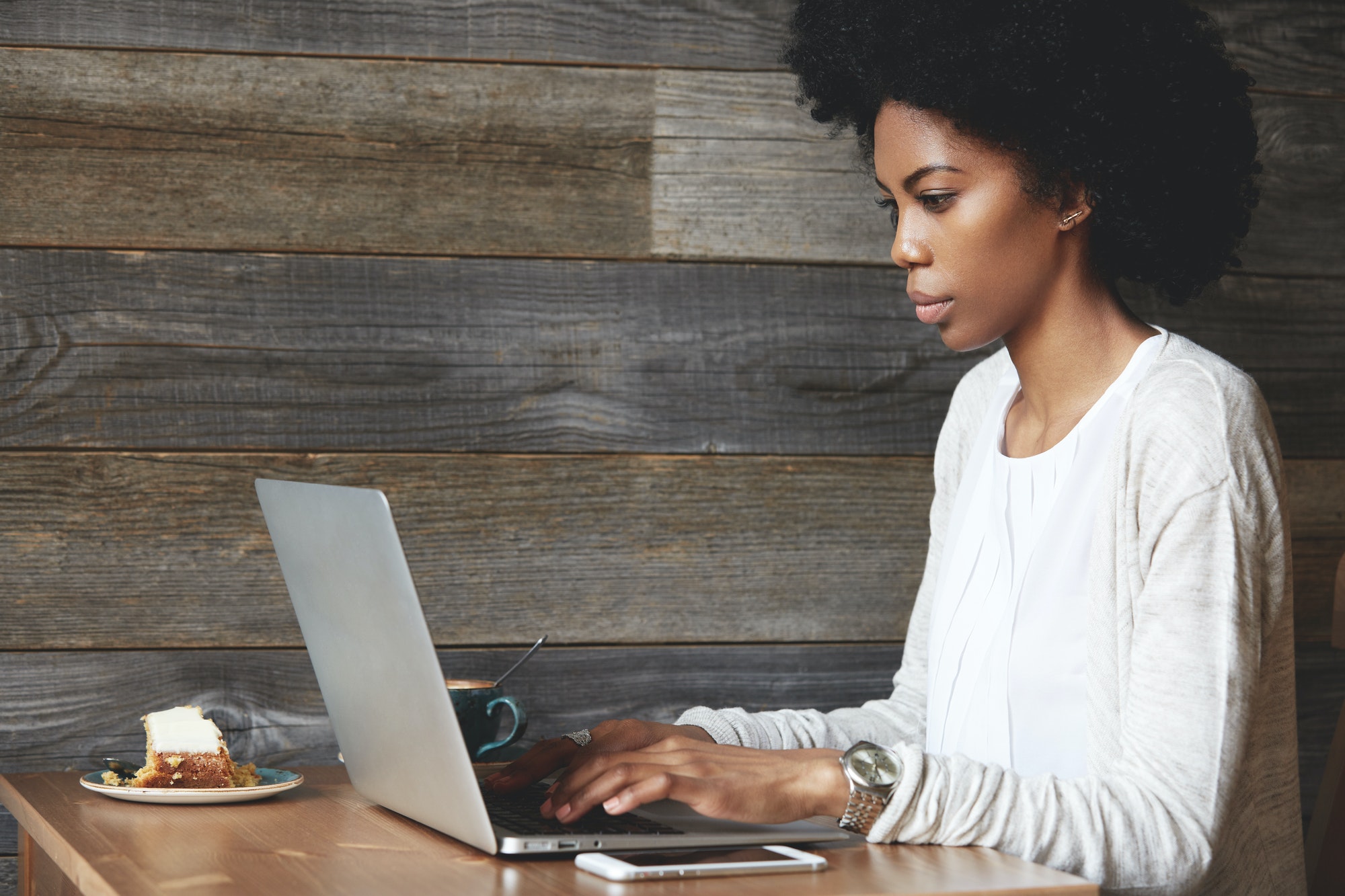 Portrait of young attractive African female blogger, typing a new challenging post during lunchtime