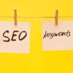 white stickers with the words SEO and keywords on a yellow background, attached to a rope