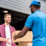 african american courier giving delivery box to customer