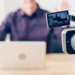 cropped image of male video blogger recording vlog in office, camera on foreground