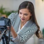 Beautiful young woman setting up the camera