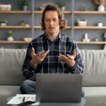Man Video Calling At Laptop Having Virtual Meeting At Home