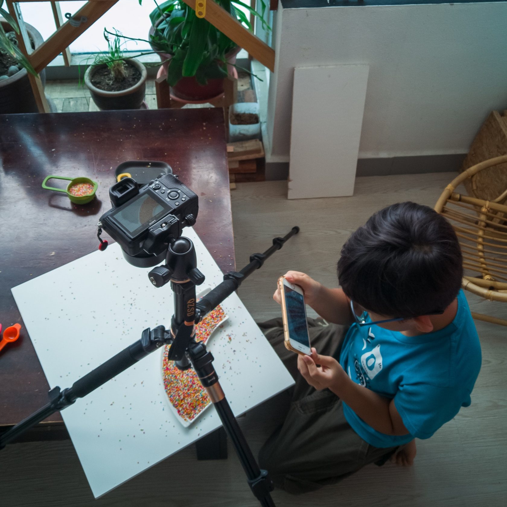 Behind the scene of stock photography at home. Child learning taking photograph to improve skill.