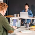 Young male software developer looking at electronic sketches of new mobile app