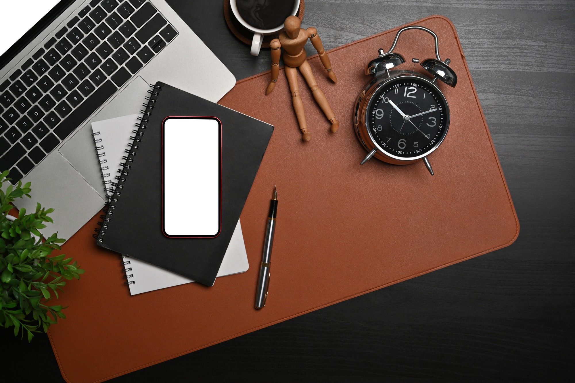 Above view smart phone, laptop, notebook and clock on black table.