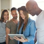 Four adults interested with something on tablet
