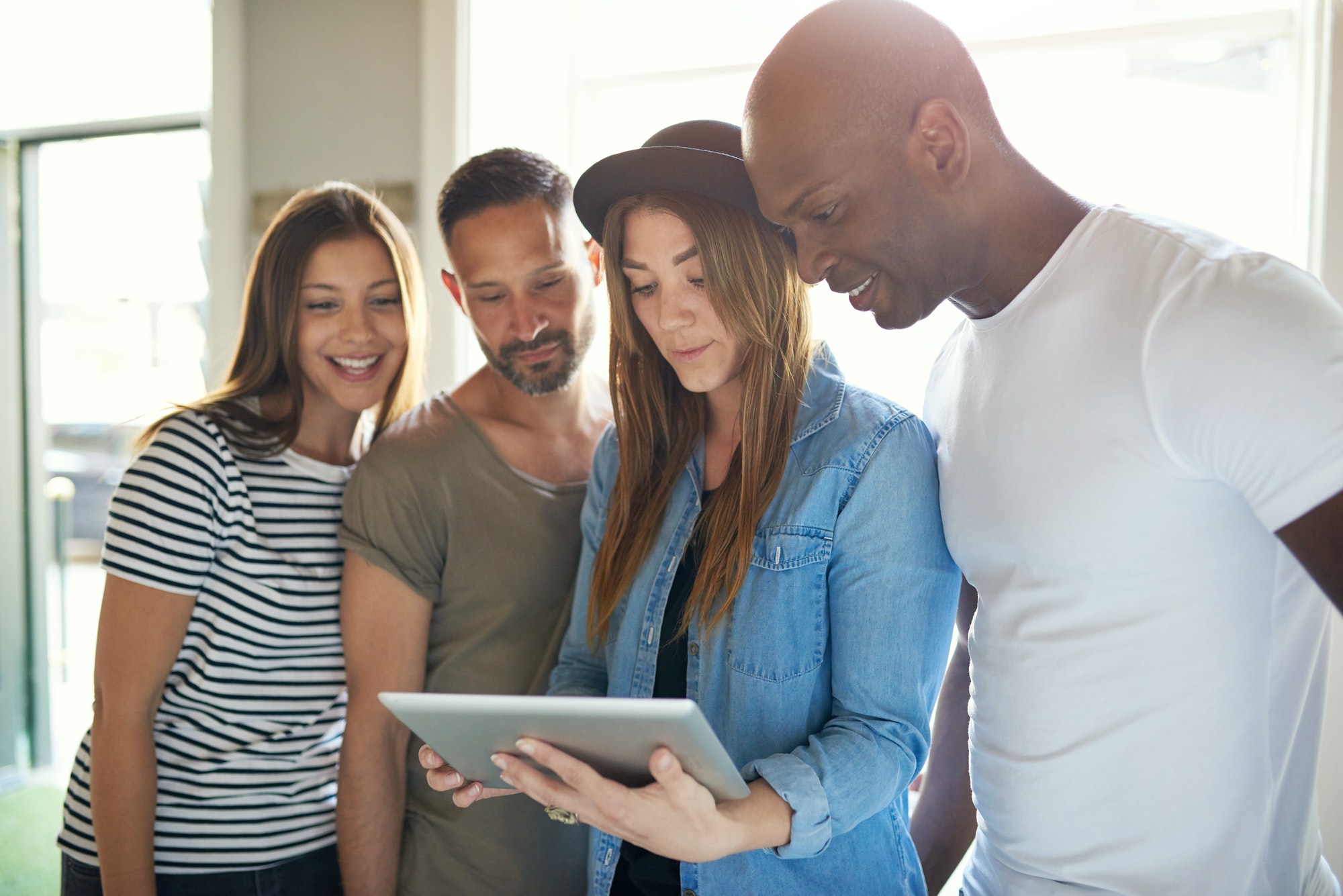Four adults interested with something on tablet