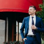 Intelligent male banker dressed in formal outfit, keeps hand in pocket