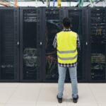 Male informatic engineer working inside server room database