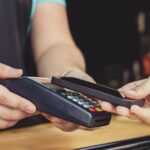 Person paying pay through smartphone using NFC