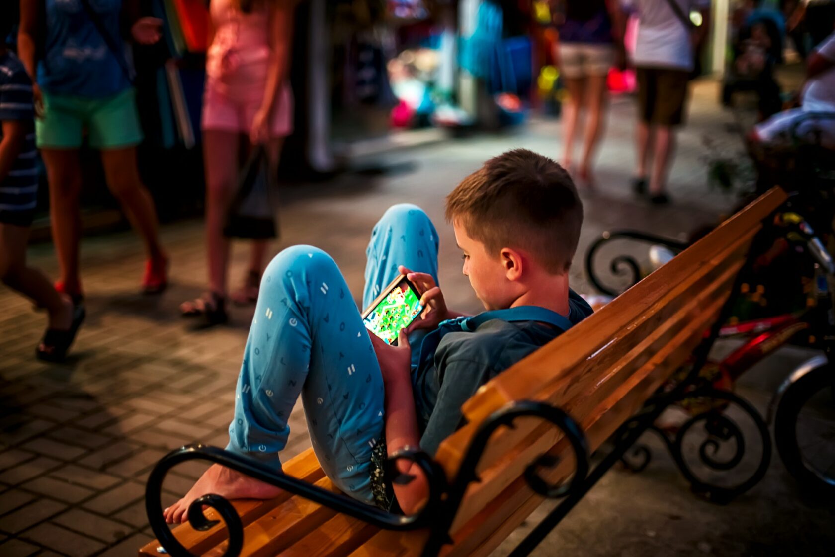 Boy playing games on android smartphone in the street