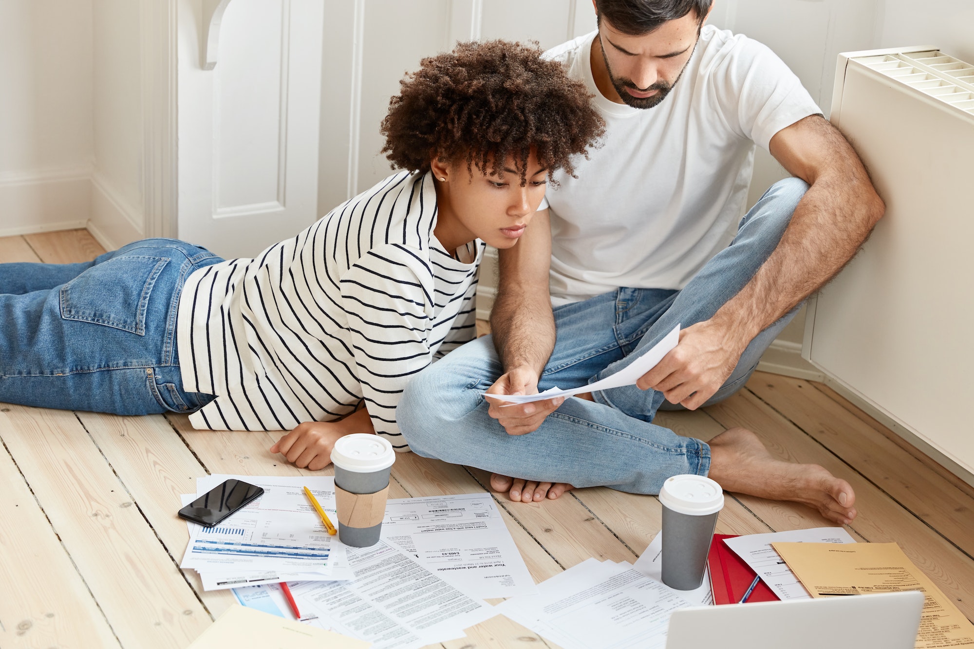 Family couple maintains home accounting, discuss plans and future payments, surrounded with bills on