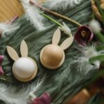 Happy Easter! Stylish wooden bunny ears and natural eggs, spring flowers
