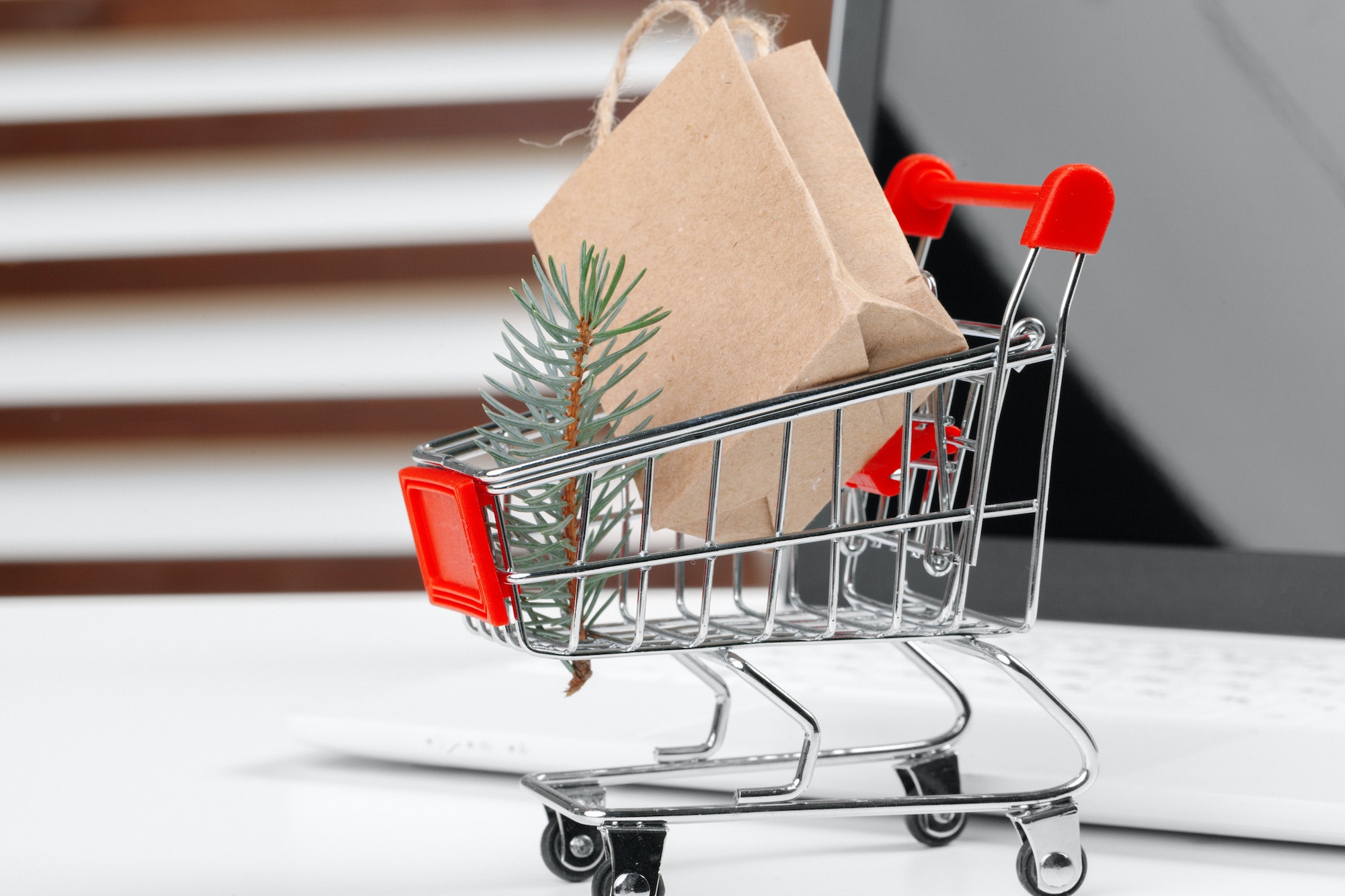 Online shopping concept. Shopping cart, laptop on the desk