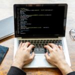 Man programming on a computer, office background