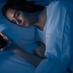 Woman sleeping with smartphone in bed