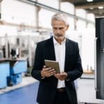 Manager using digital tablet in high tech company